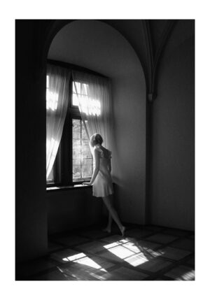 Mujer en monocromo junto a una ventana