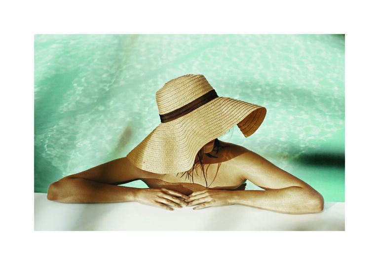 Relajación Junto a la Piscina con Sombrero de Paja