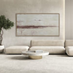 Salón minimalista con cuadro abstracto horizontal en tonos arena